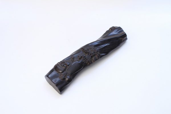 A carved wooden wristrest
