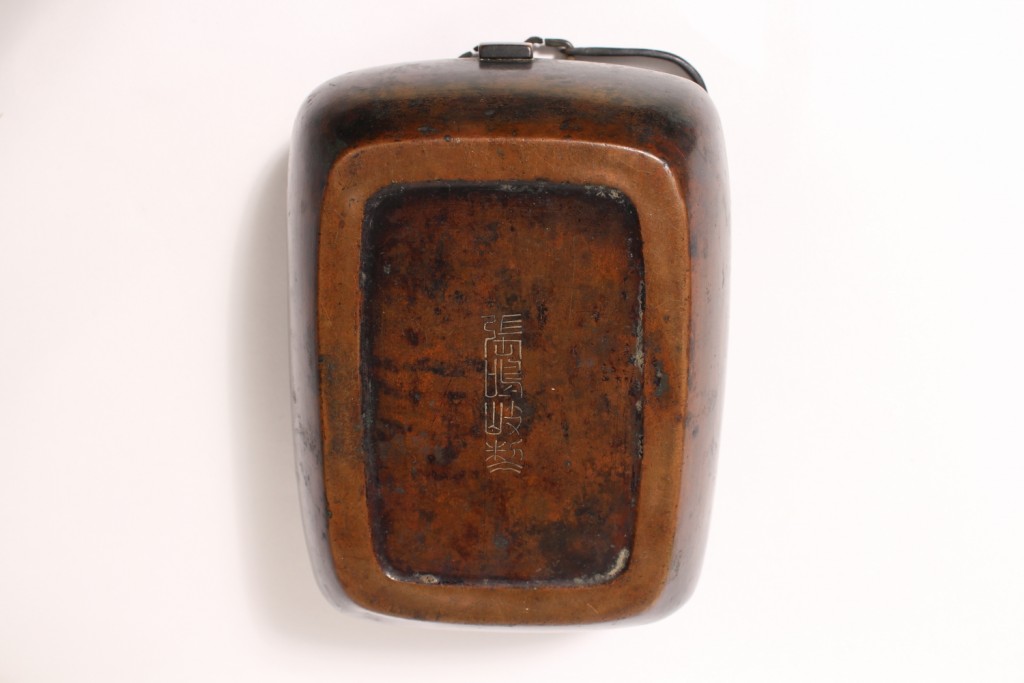 A bronze hand warmer and cover