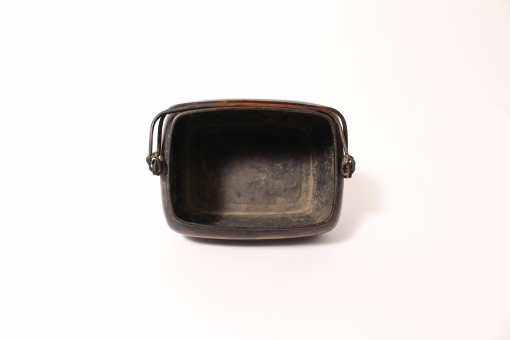 A bronze hand warmer and cover