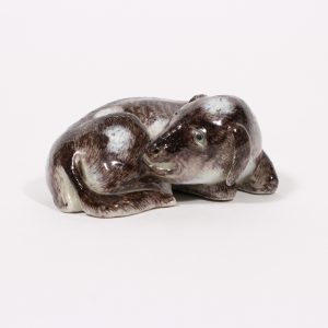 A finely glazed figure of a recumbent dog with incised red mark (Qing dynasty, 18th/19th century)