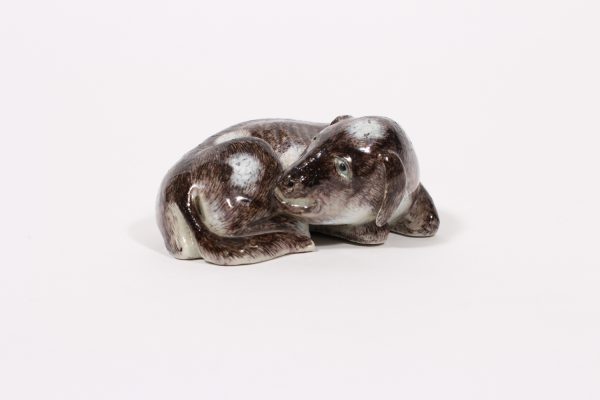 A finely glazed figure of a recumbent dog with incised red mark (Qing dynasty, 18th/19th century)